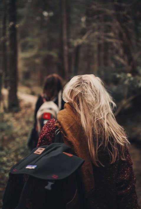 dont-get-lost-let-us-show-you-the-way Two people walking single file along a path through the woods.